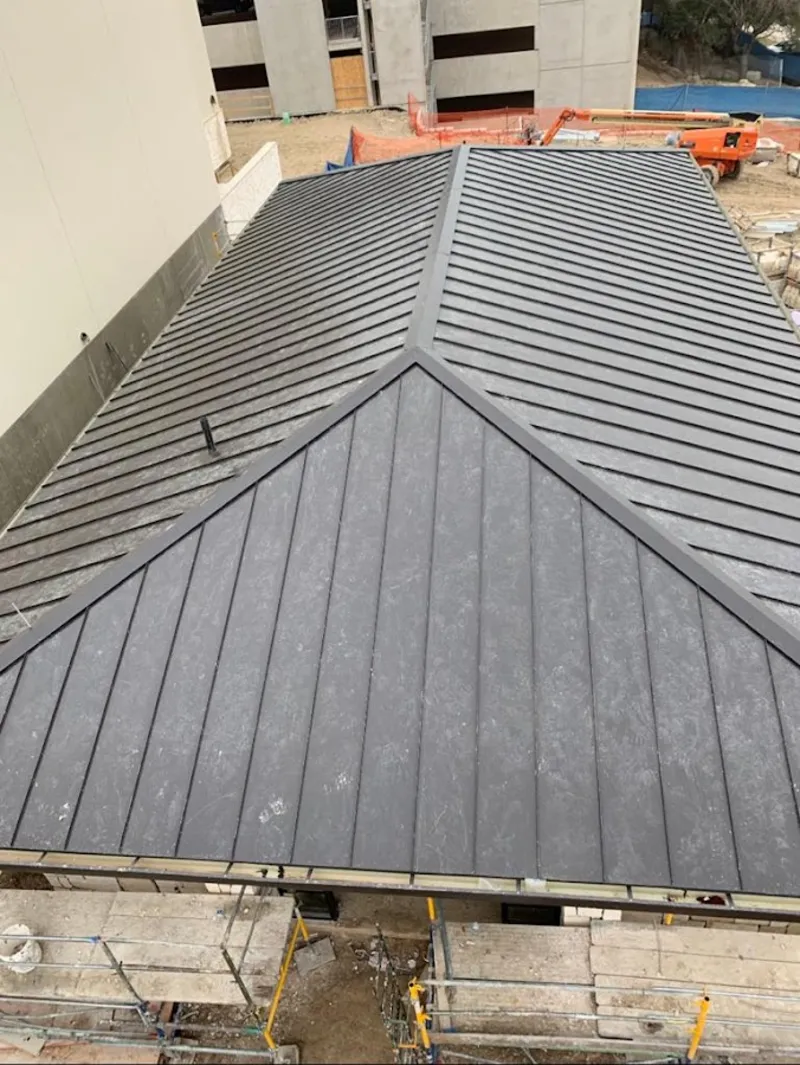 Commercial metal roof construction with crane equipment in Estacada